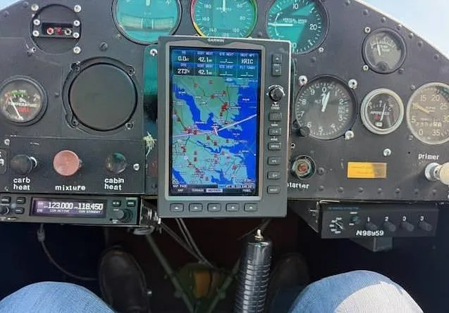 The cockpit instrument panel of an aircraft, featuring a Garmin GPS display and various gauges, with the N-number N98959 visible.