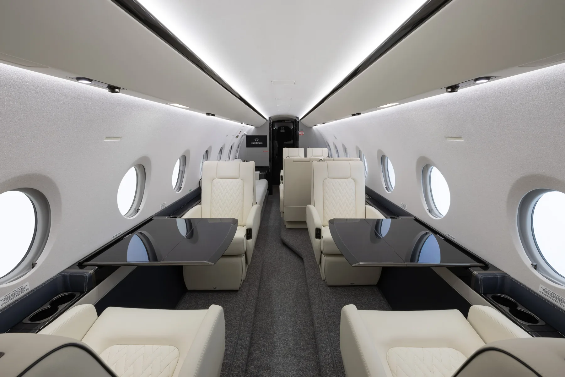Interior view of the aircraft cabin with seating and tables.