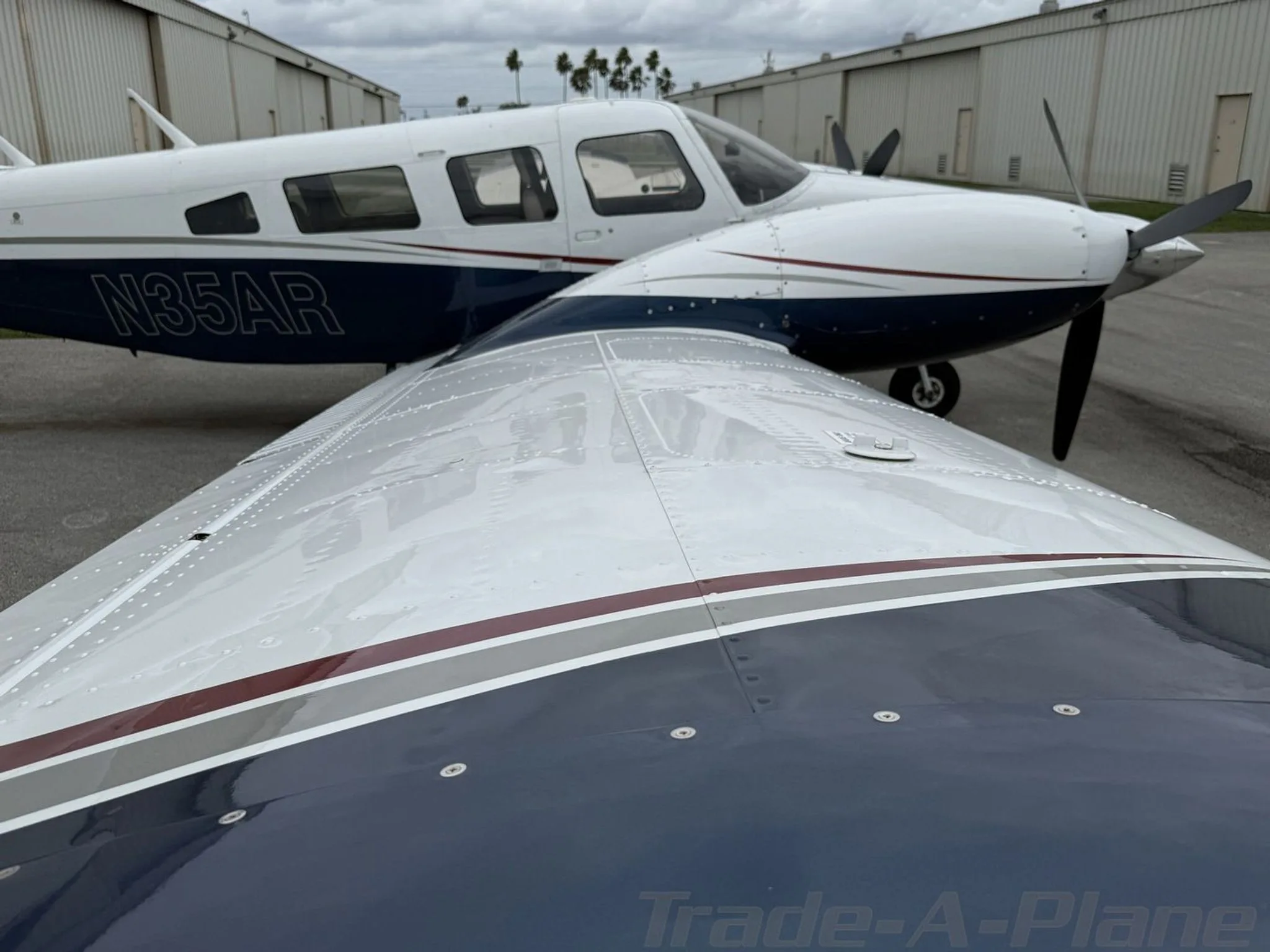 View over the wing of the white and blue aircraft N35AR, showing the fuselage and the right engine.