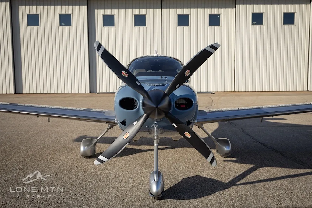 A head-on view of the Cirrus SR22T aircraft, N902KD, showing its propeller and nose.
