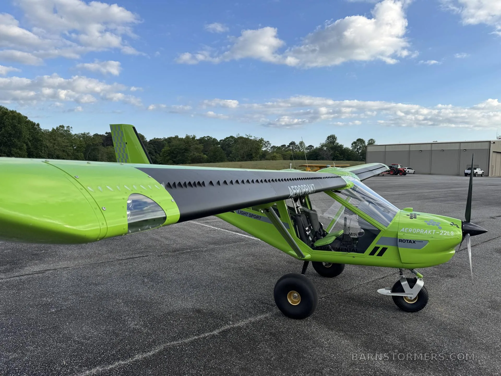 A bright green Aeroprakt A22LS light sport aircraft on an airfield, accompanied by a detailed weight and balance equipment list.