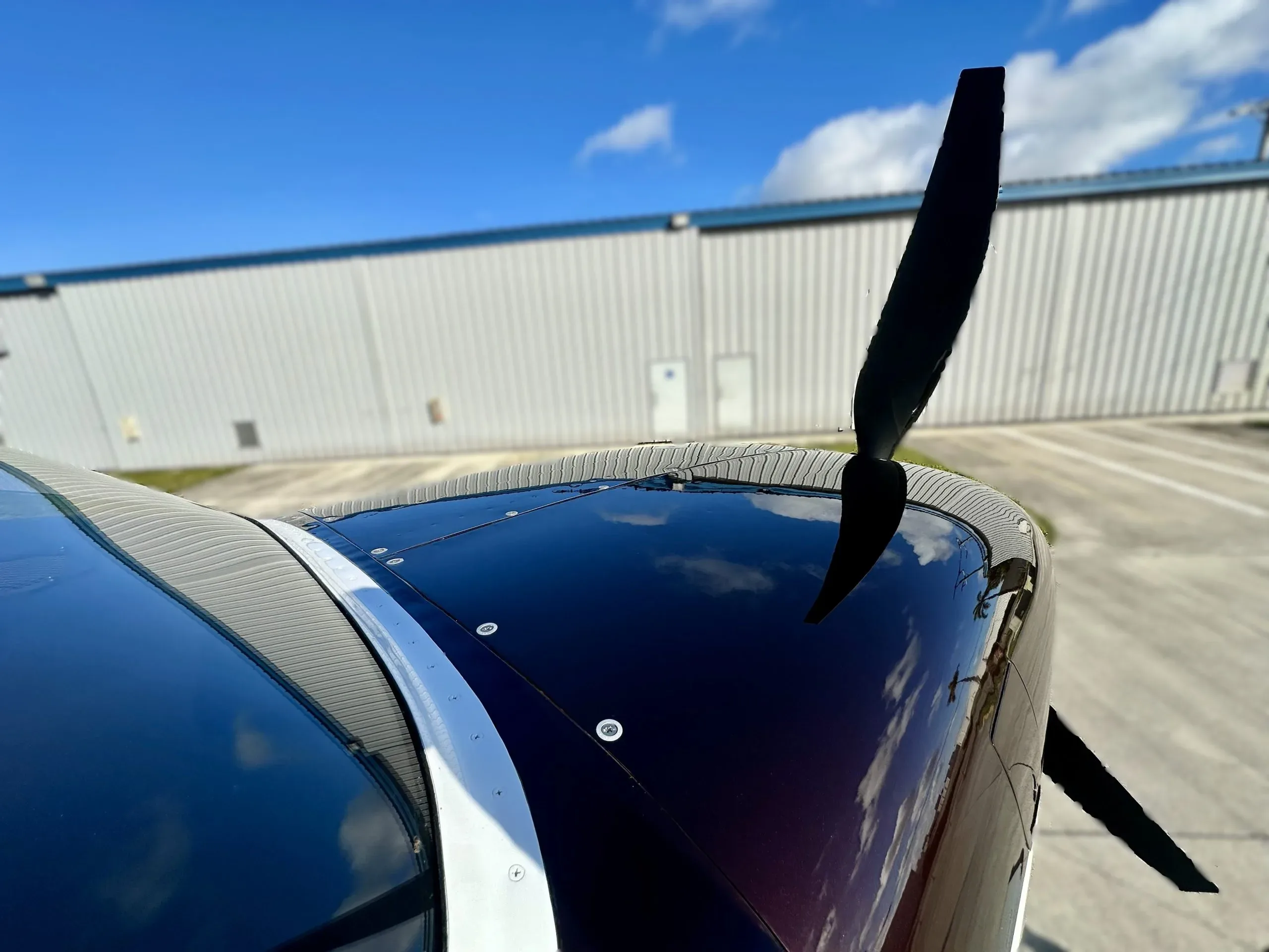A close-up of the propeller and dark brown engine cowling of the Cessna seaplane.