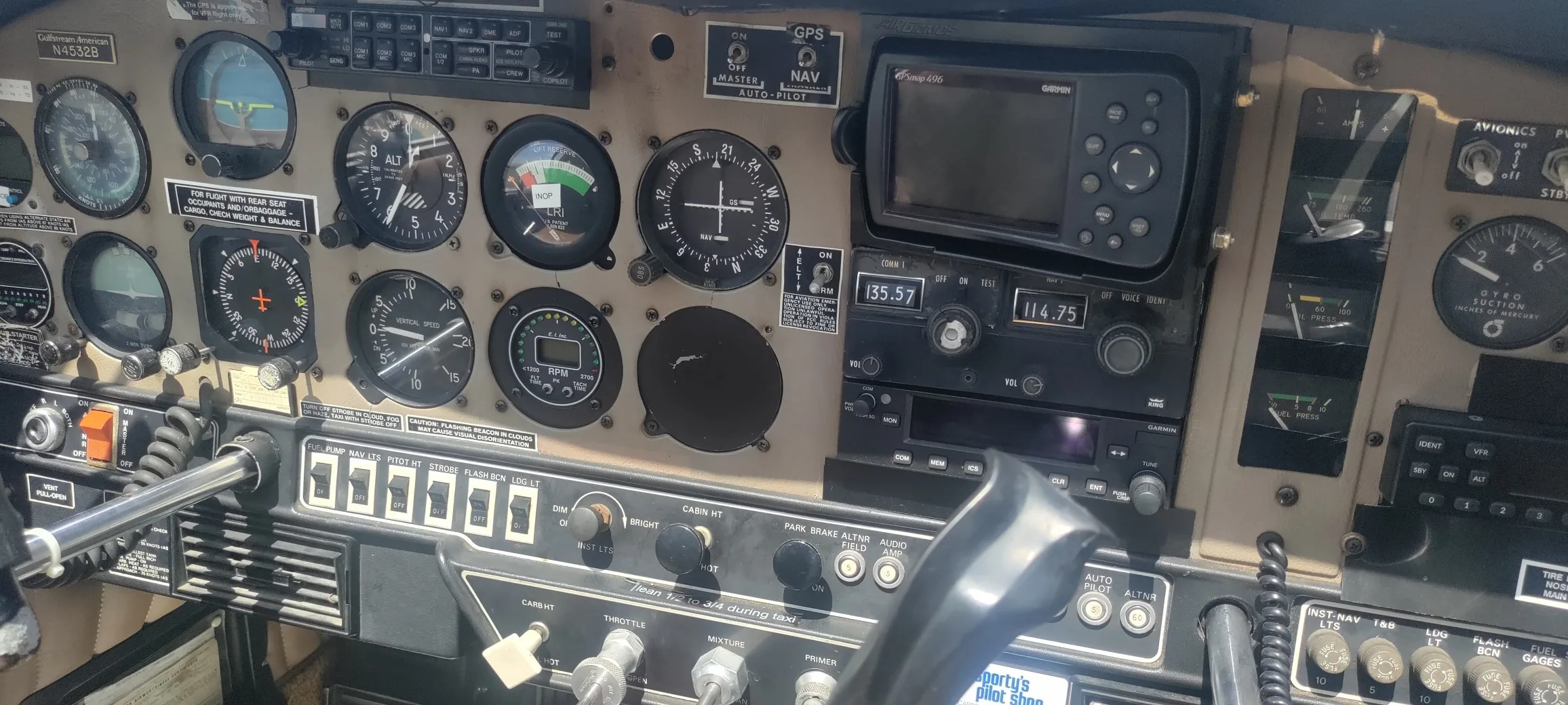 A close-up view of the cockpit instrument panel of a Gulfstream American aircraft, featuring analog gauges and a Garmin GPS.