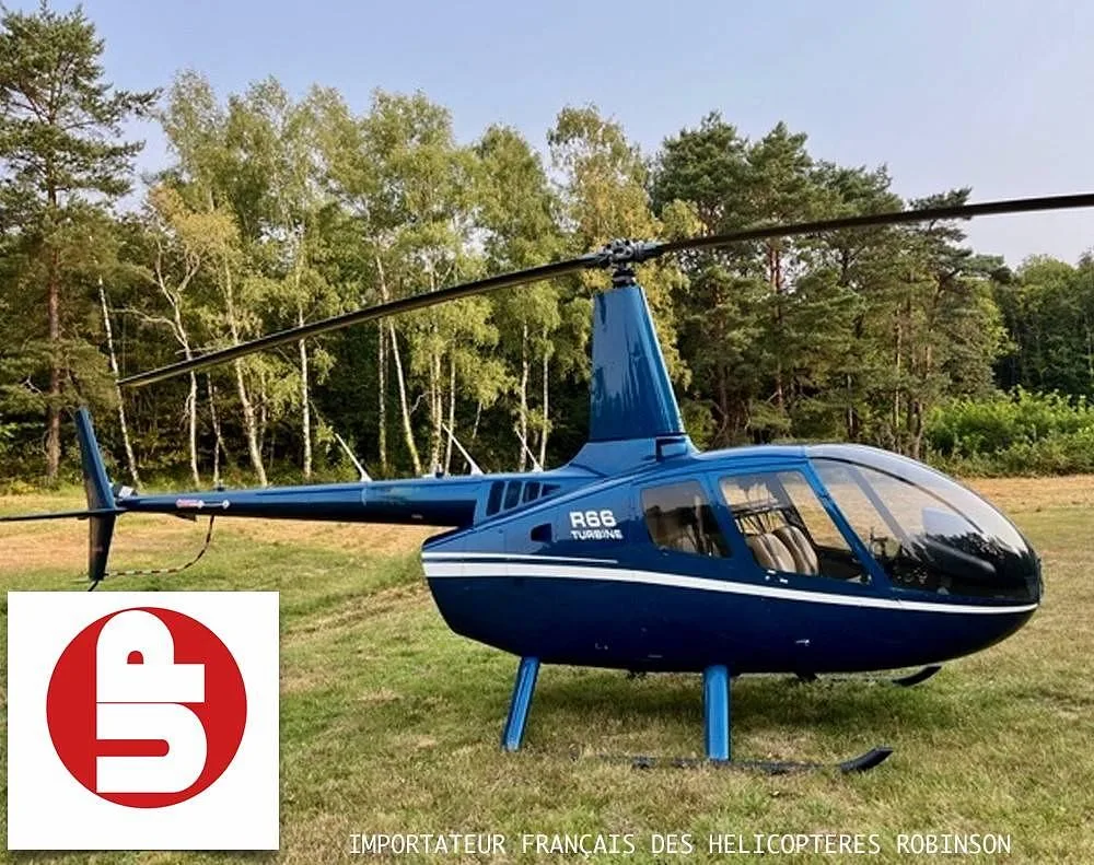 A blue Robinson R66 Turbine helicopter with white stripes sits on a grassy field.