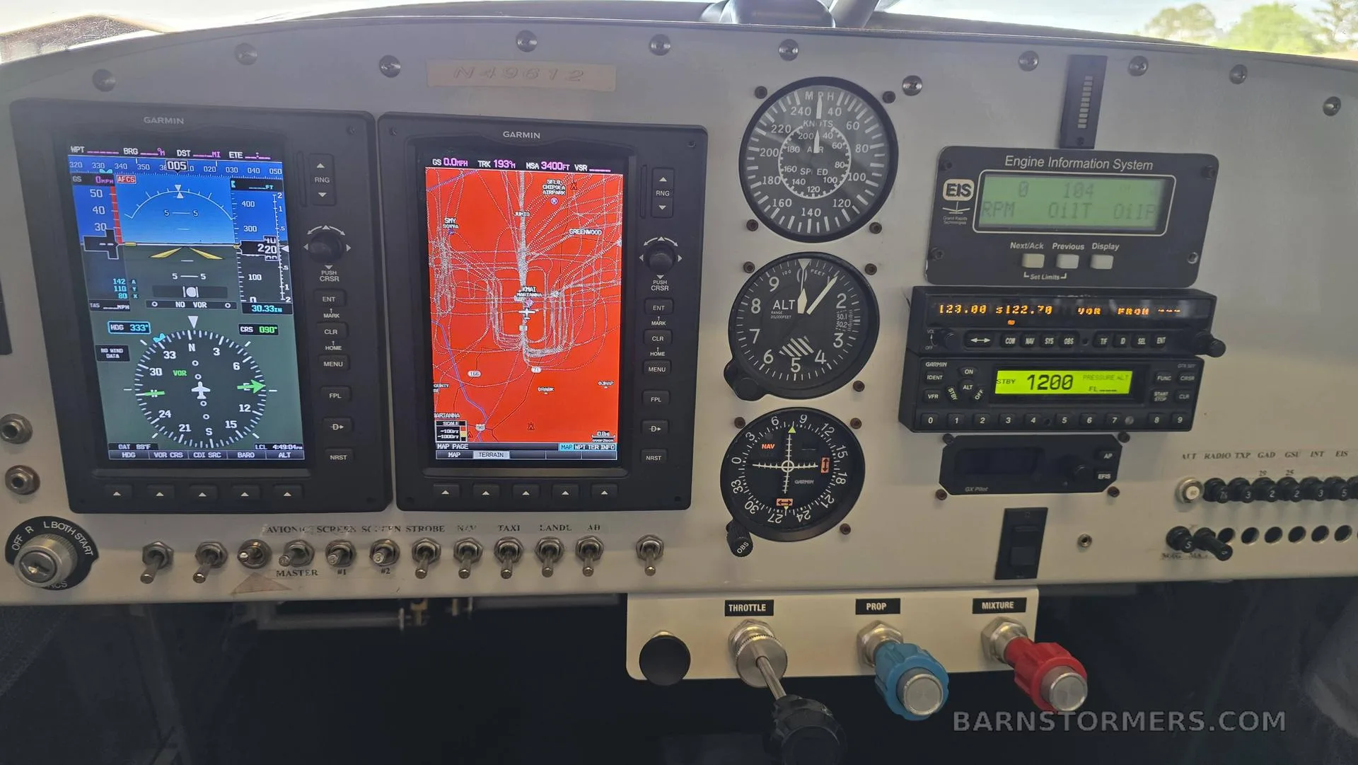 The cockpit instrument panel of an aircraft, featuring two Garmin G3X Touch displays, analog gauges, and engine controls.