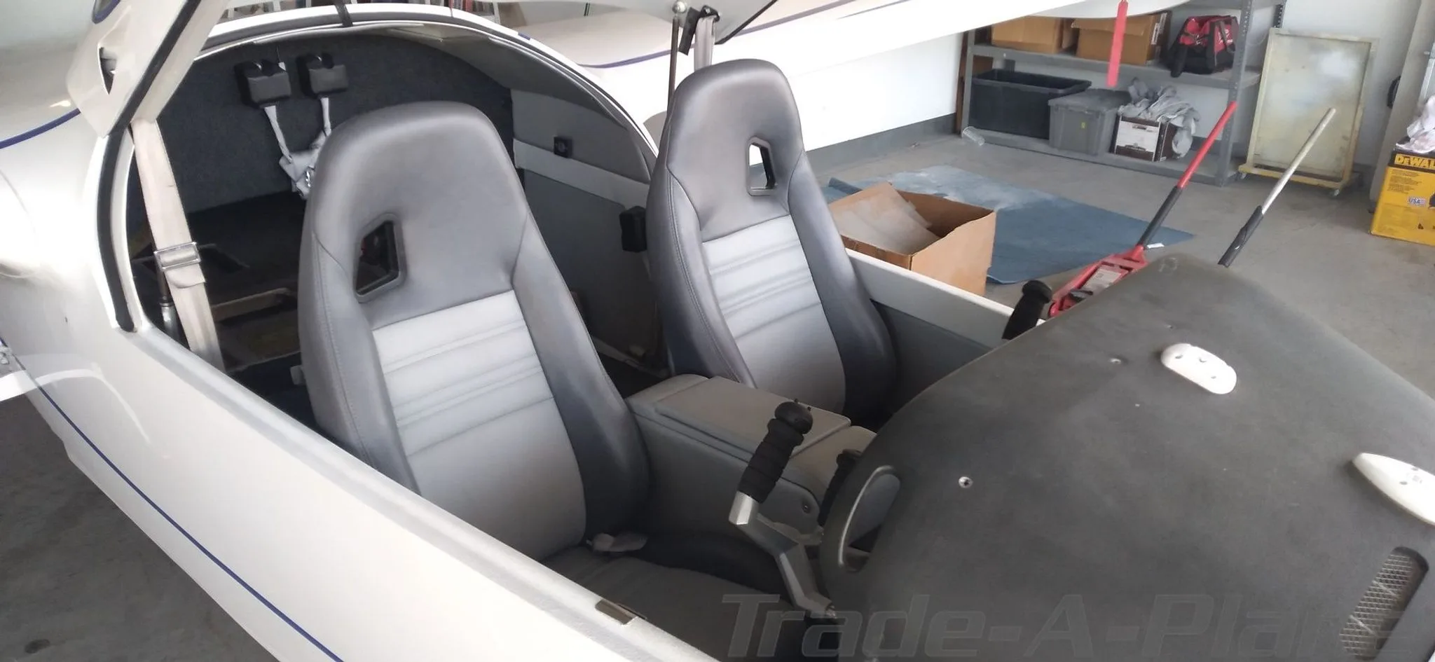 The interior cabin of the Searey aircraft, showing two grey and white seats and the side console.