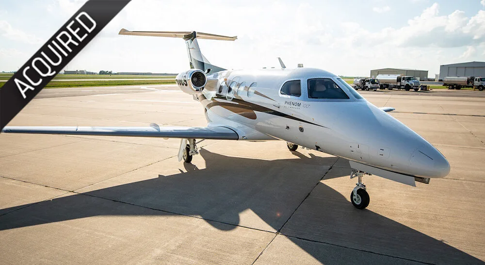 An Embraer Phenom 100 business jet with registration N400EJ parked on an airport tarmac.