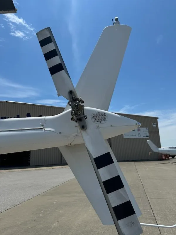 Close up of the tail rotor of a white Bell 206L-4 helicopter.
