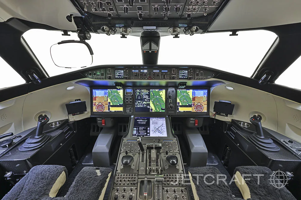 The modern cockpit of a Bombardier Global 7500 with multiple digital displays and side-stick controls.