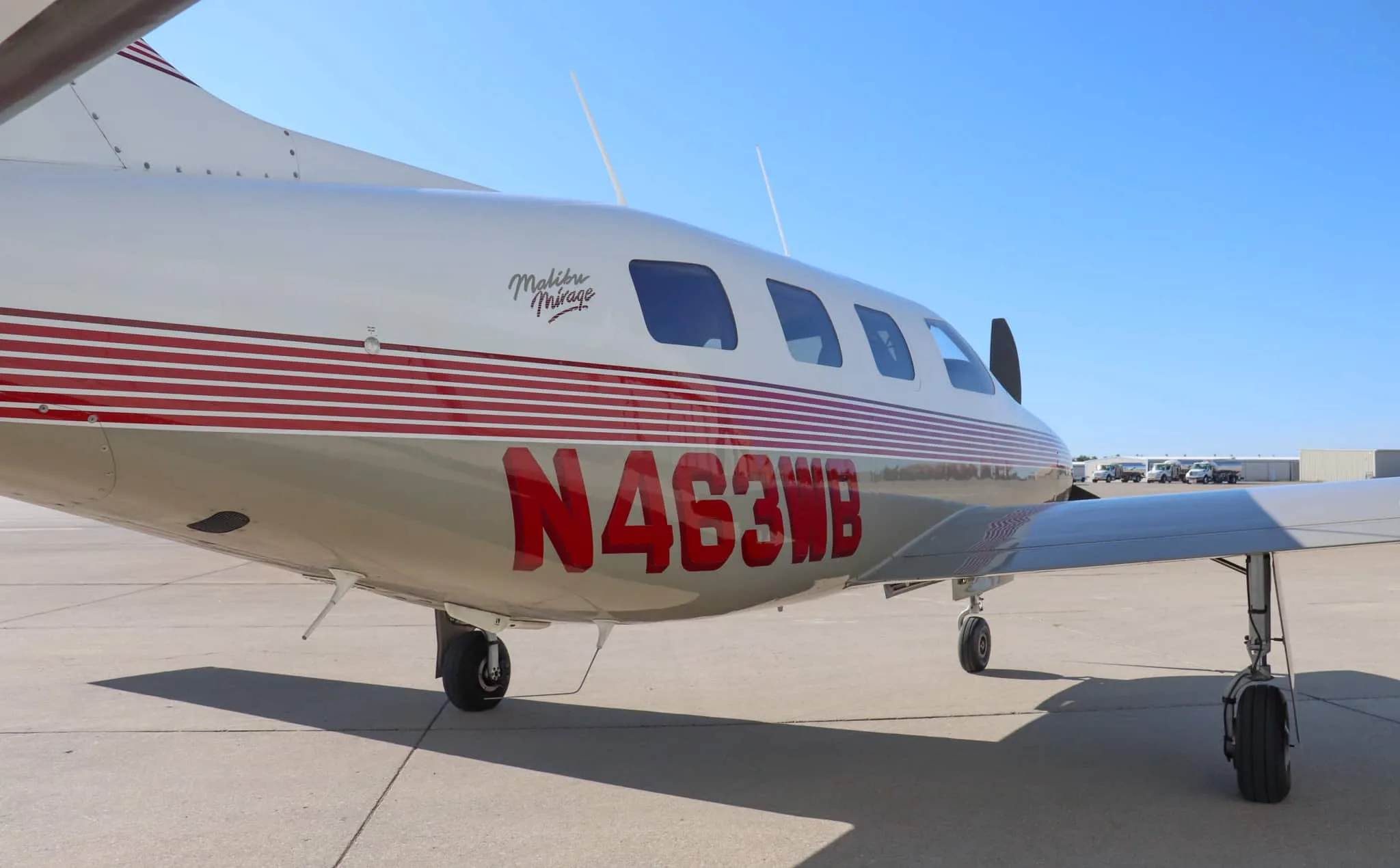 A close-up side view of the Piper Malibu Mirage N463WB fuselage, highlighting the red N-number and "Malibu Mirage" script.
