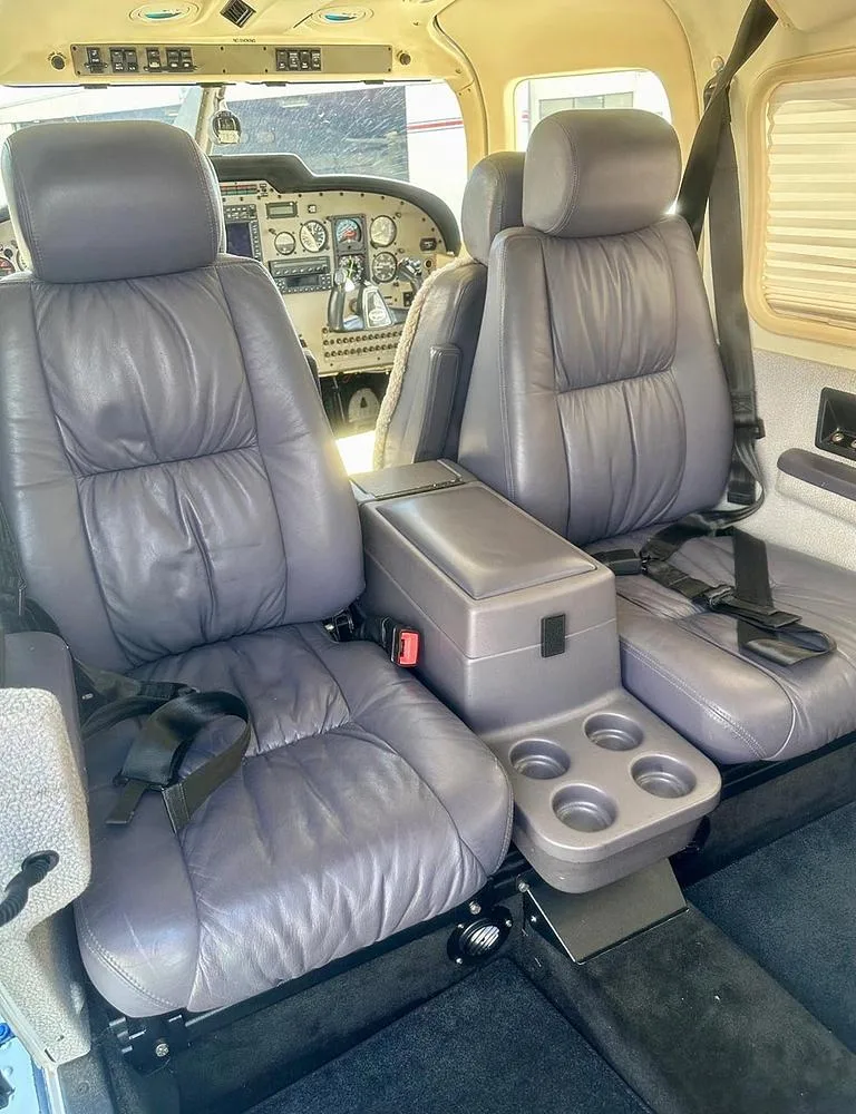 The gray leather passenger seats and center console of the aircraft cabin.