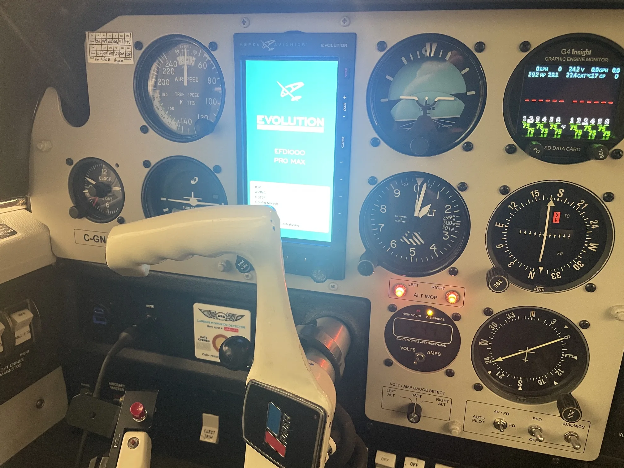The cockpit instrument panel of an aircraft, featuring an Aspen Evolution display and traditional gauges.