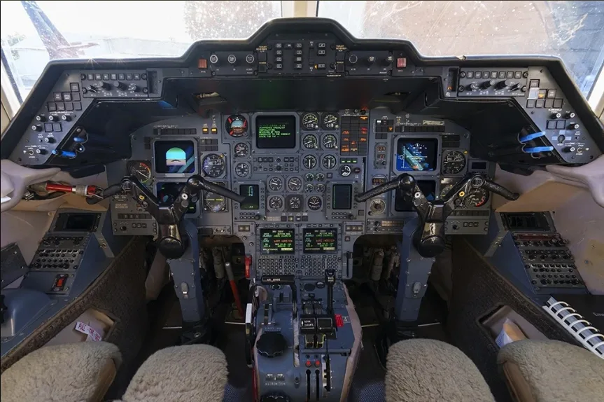 The detailed cockpit of a business jet, featuring multiple analog gauges and digital displays.