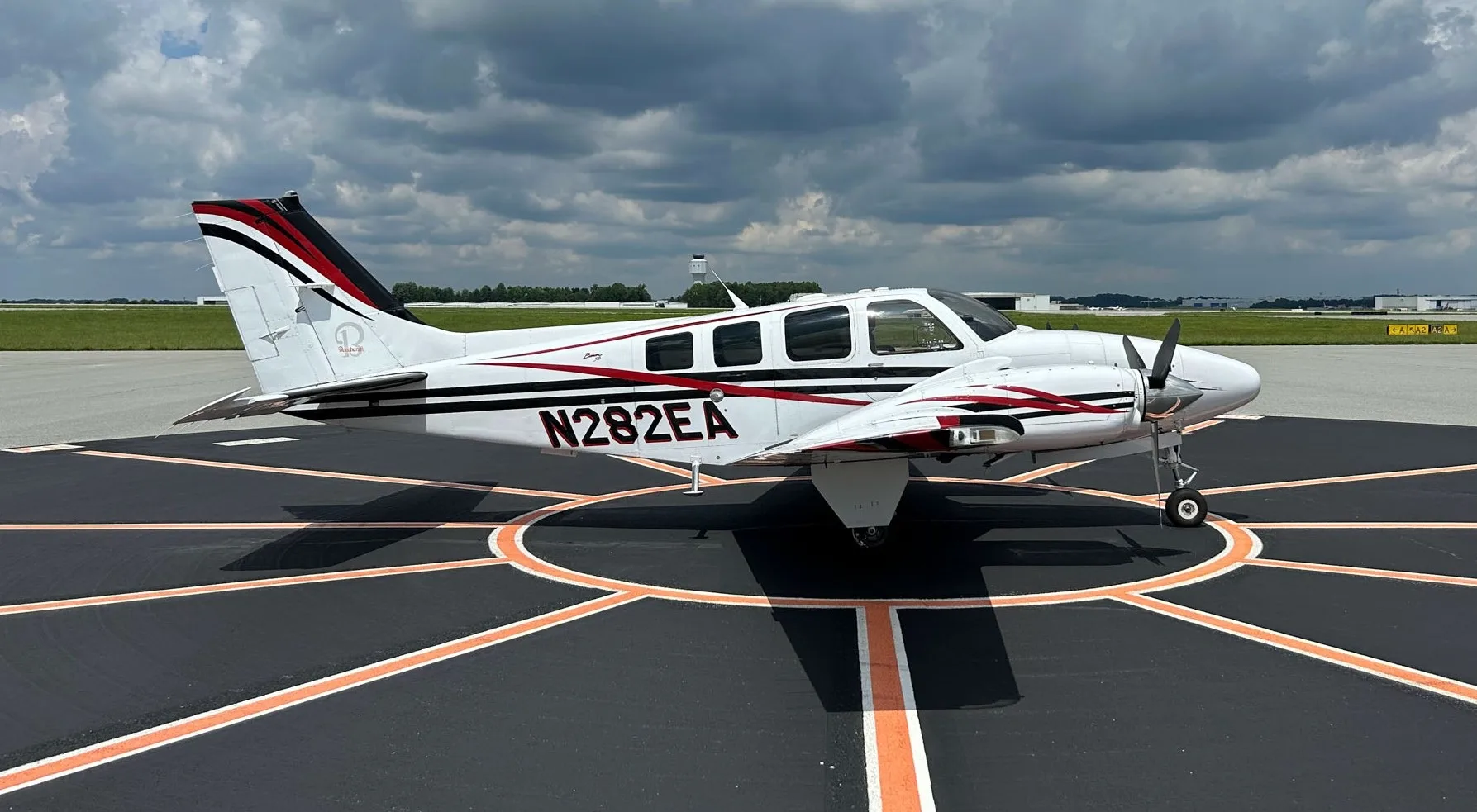 Beechcraft Baron on the tarmac with white and red paint scheme.