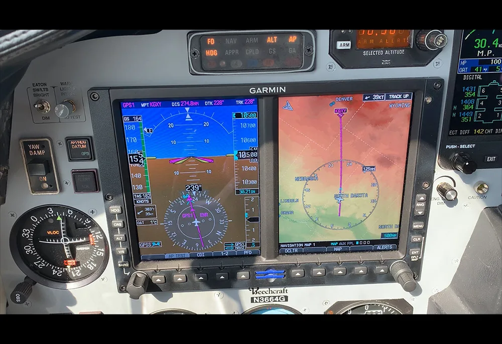 A close-up of the Garmin glass cockpit displays showing flight information and a navigation map.