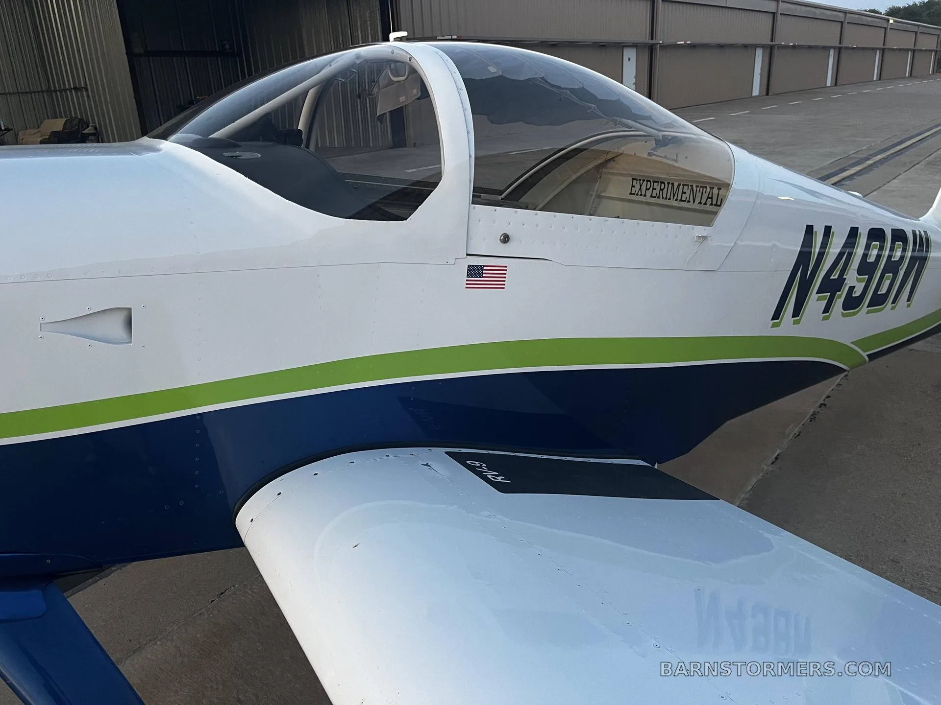 A close-up side view of the blue and white experimental aircraft N49BW, showing the cockpit canopy and wing.