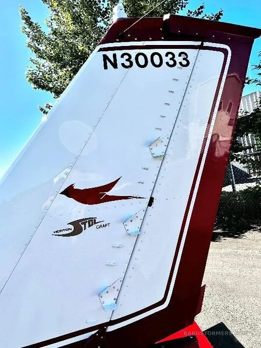 A close-up of the aircraft's white and red tail fin, showing the registration N30033 and a "Horton STOL Craft" logo.