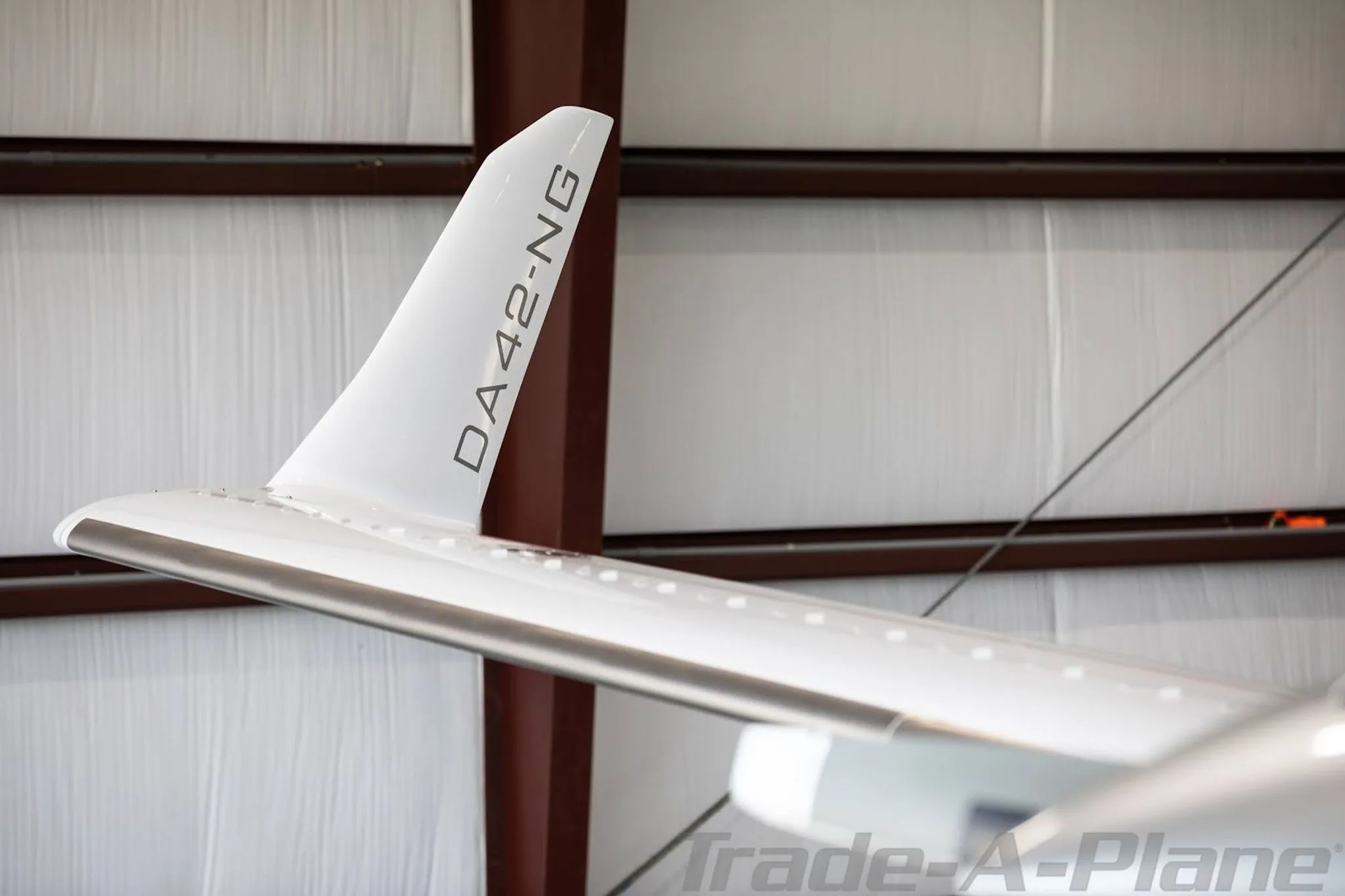 A close-up view of the right wingtip of a white Diamond DA42-NG aircraft, showing the 'DA42-NG' designation.