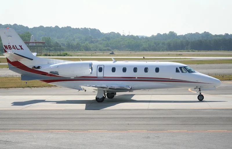 A side view of the Cessna Citation CJ1+ aircraft with registration N84LX on the tarmac.