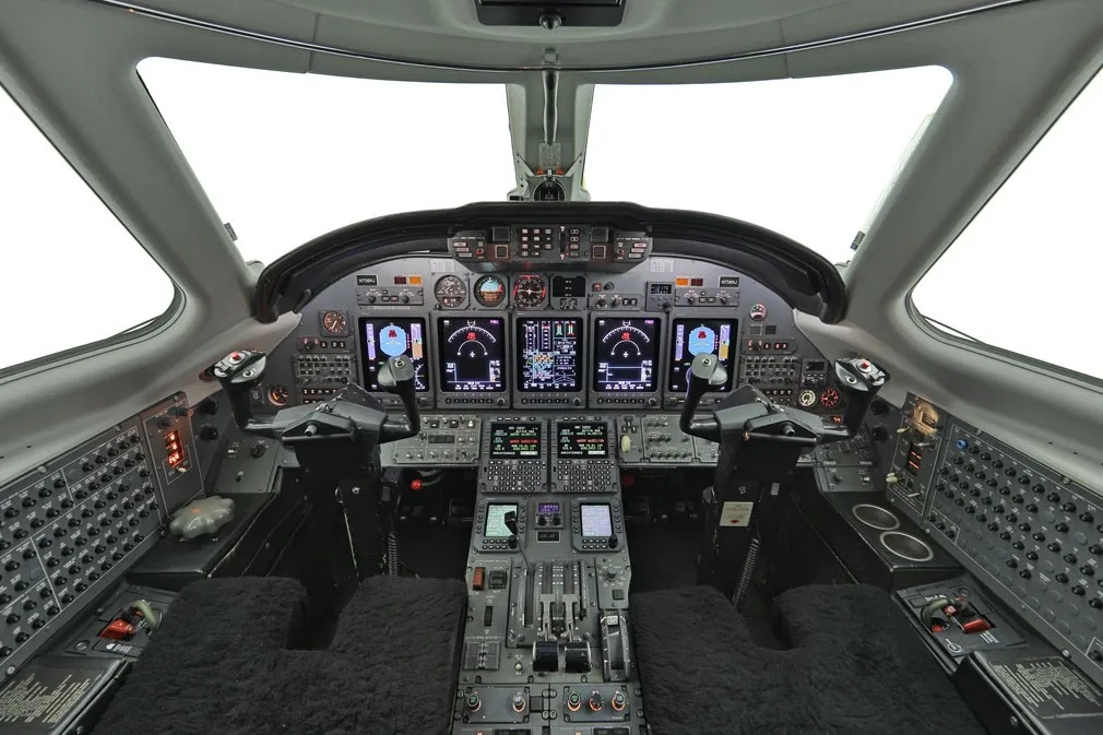 Aircraft cockpit instrument panel with multiple displays and controls.