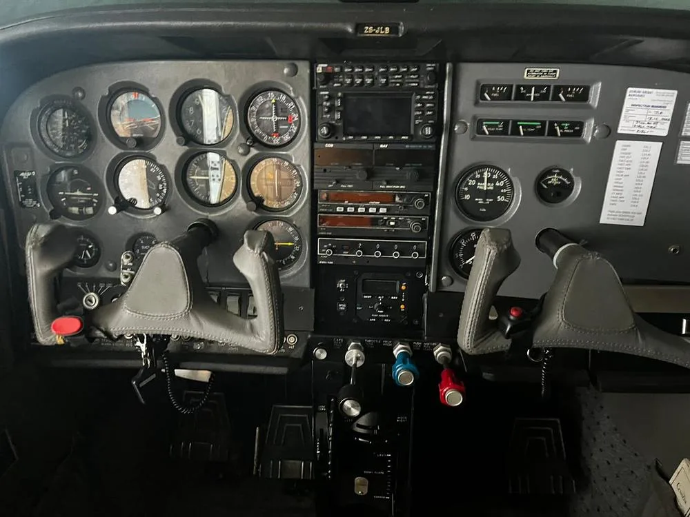 The cockpit instrument panel of an aircraft, featuring various gauges, avionics, and control yokes.