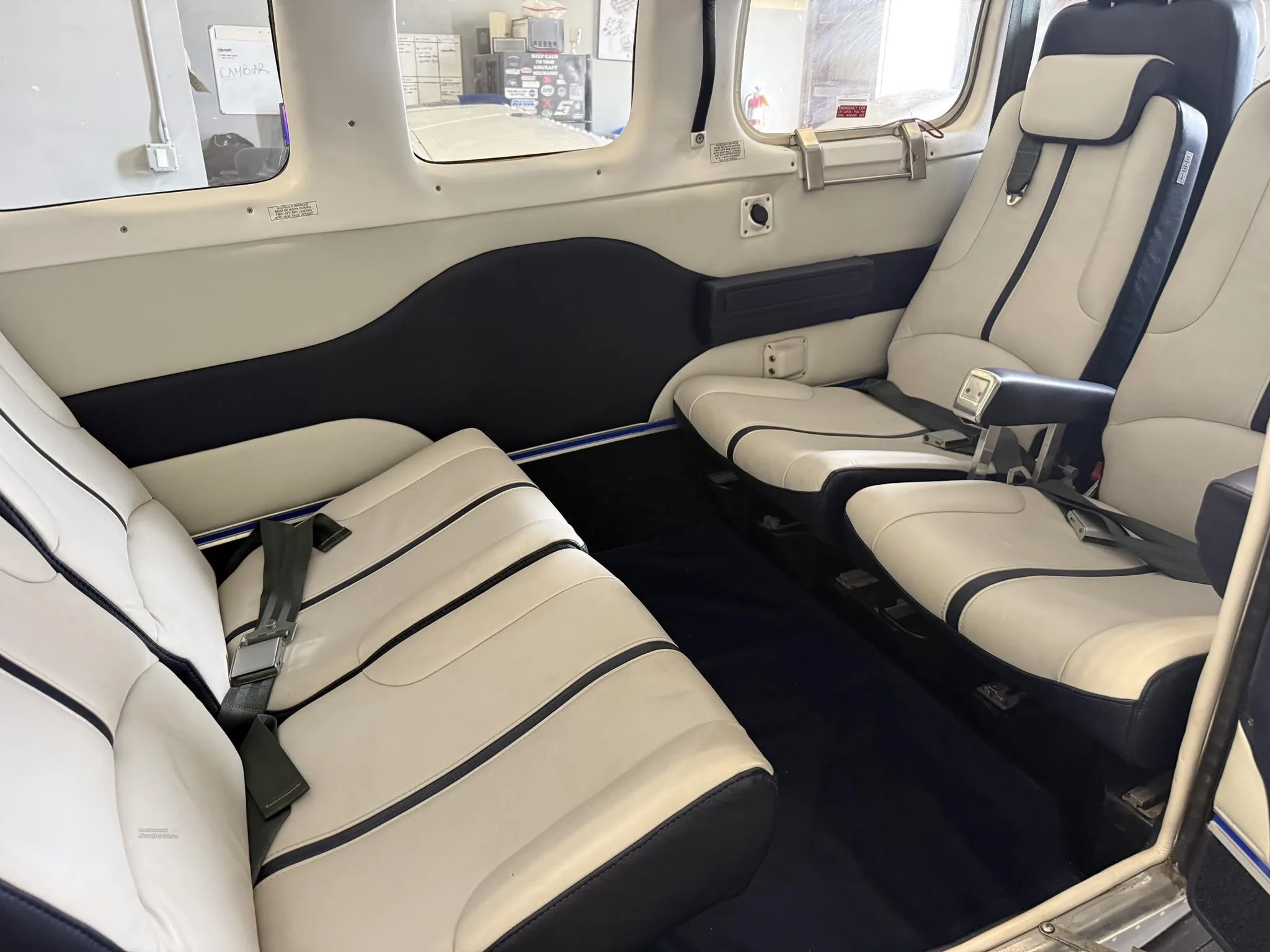 The aircraft's interior cabin with white and blue leather seats and dark blue carpet.