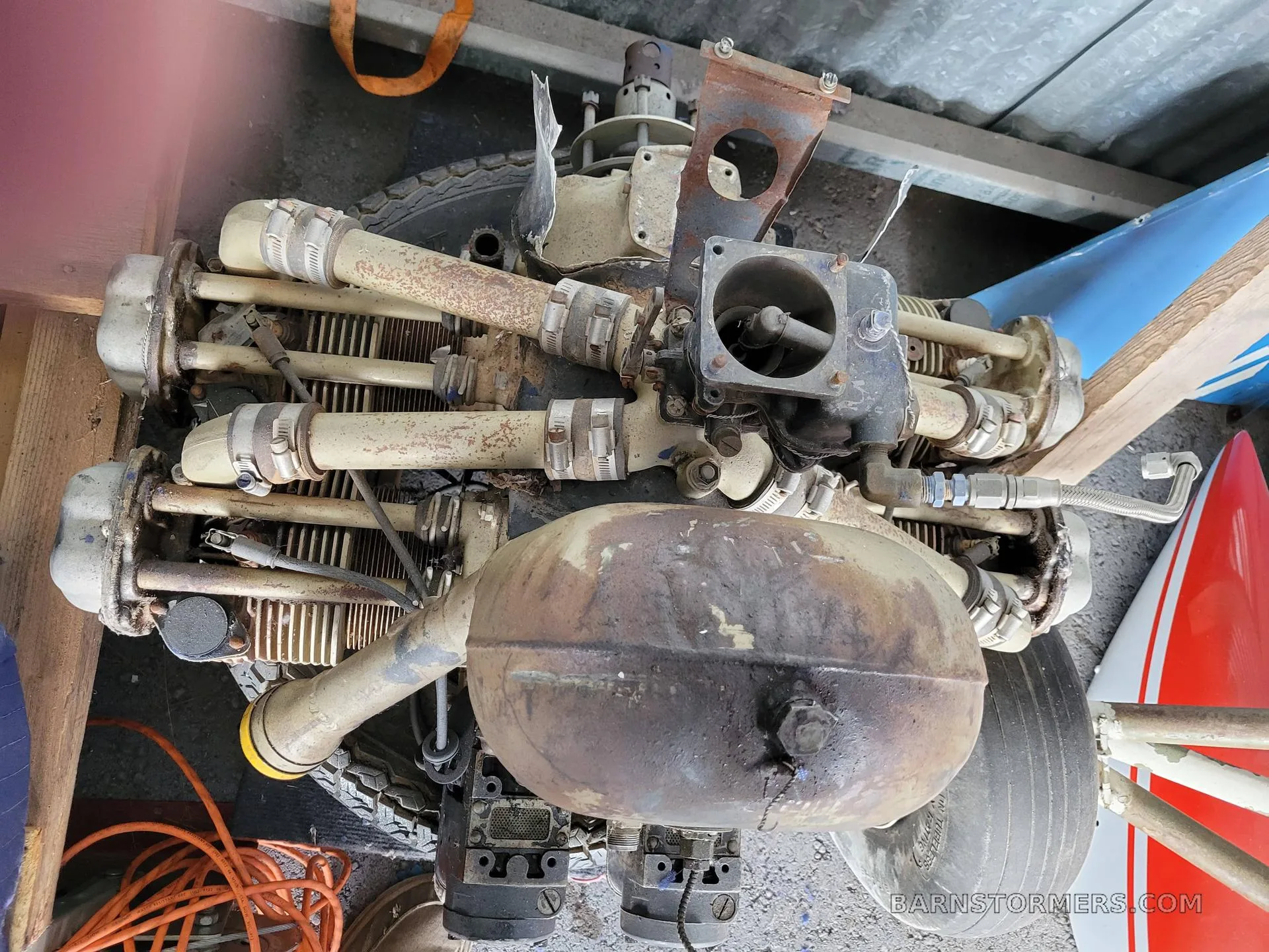 An old, disassembled aircraft engine with exposed cylinders and exhaust pipes.