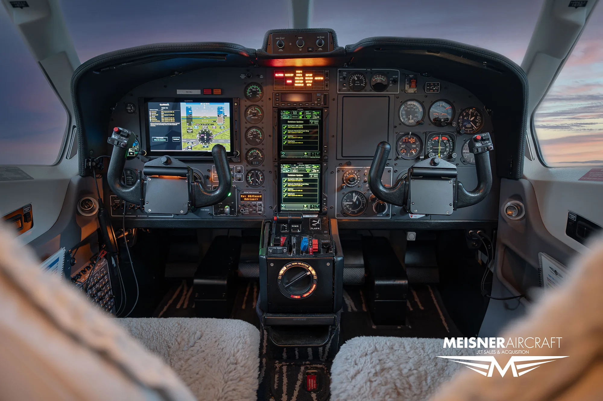 The cockpit of a TBM aircraft, showing the instrument panel with multiple screens and controls.