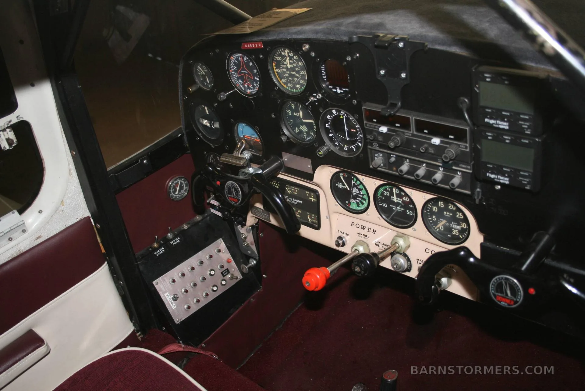 The cockpit instrument panel of a vintage aircraft, featuring analog gauges and radio equipment.