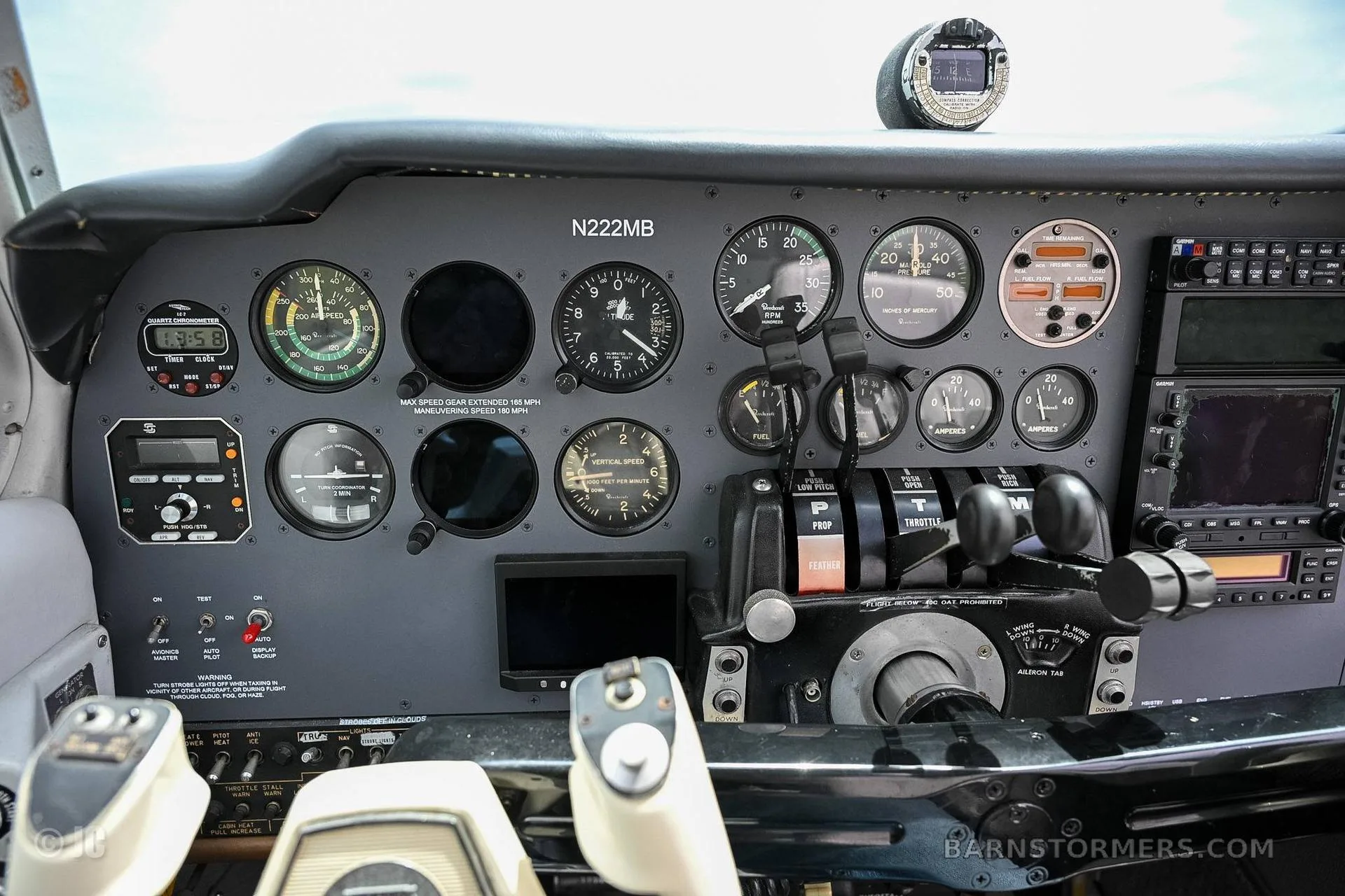 The instrument panel of a twin-engine aircraft, featuring various gauges, controls, and the registration number N222MB.