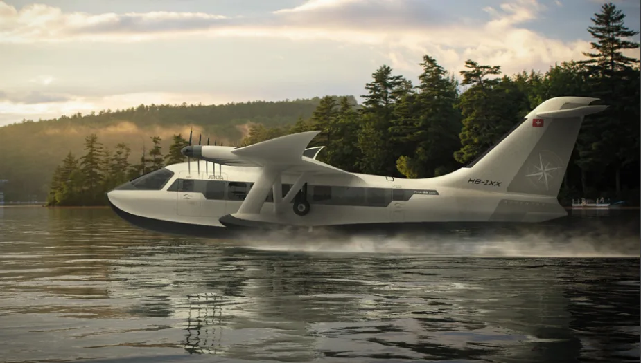 A white Jekta seaplane with twin engines on top of its wing, on a lake at sunset, with trees in the background.