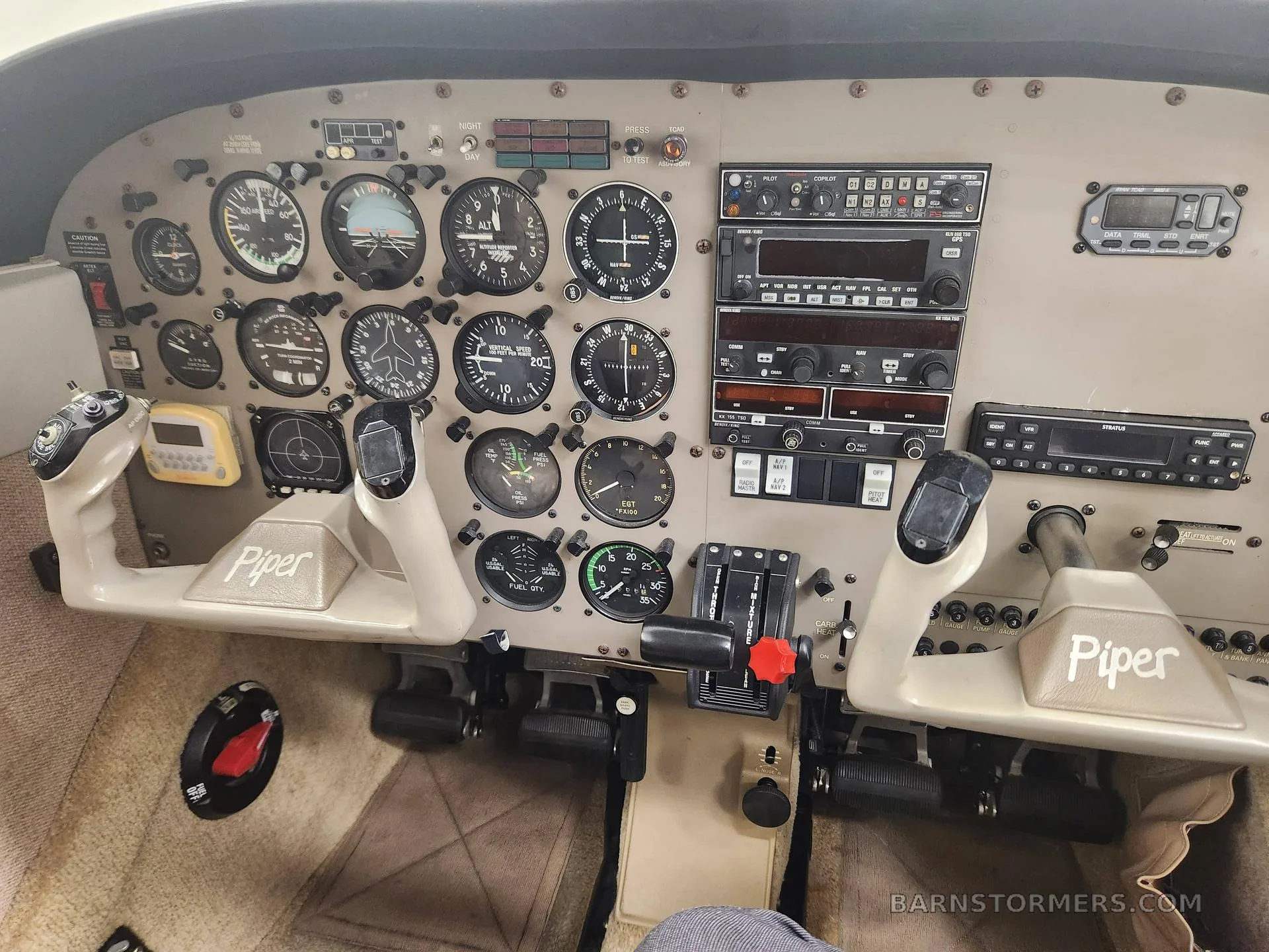 The instrument panel and dual yokes of a Piper aircraft cockpit.