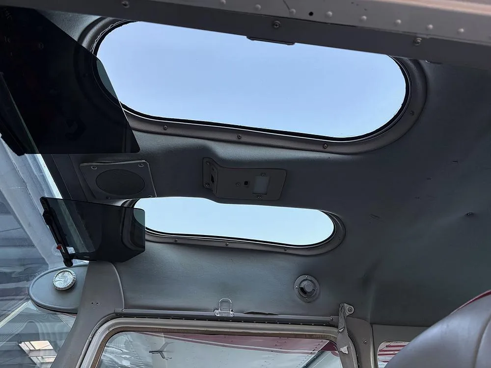 View of the aircraft's overhead panel with two oval skylight windows and sun visors.