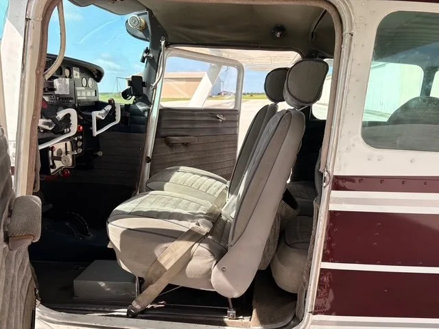 The light gray fabric seats and partial cockpit of a Cessna 182 Skylane interior.