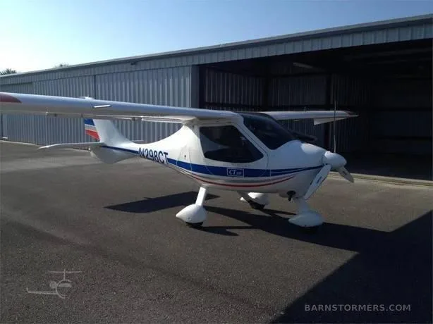 A white and blue Flight Design CTLS light sport aircraft, registration N298CT, parked in front of a hangar.