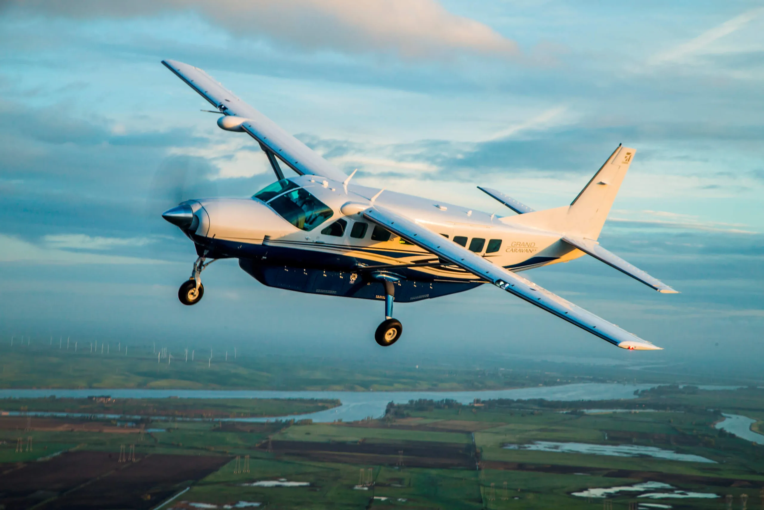 Cessna Grand Caravan in flight over a rural landscape.