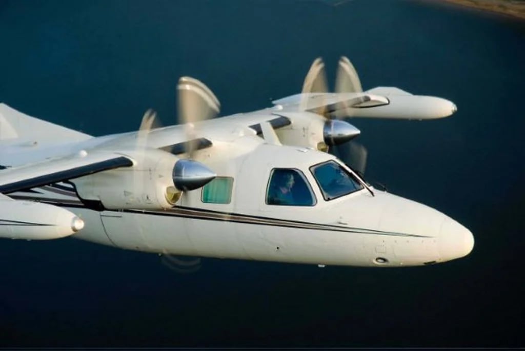 Close up of a white twin-engine aircraft in flight.