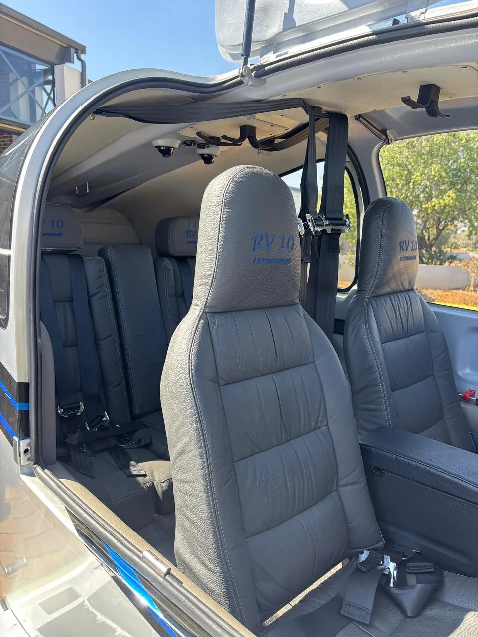 The gray leather interior cabin of a Van's RV-10 aircraft, showing four seats with "RV 10" embroidered.