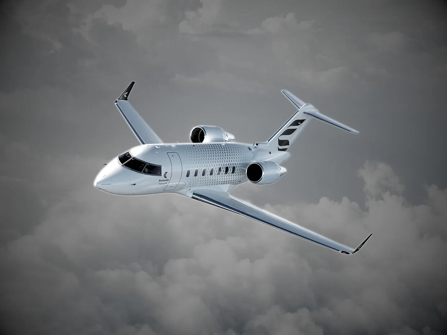 A silver business jet with dark accents flying through a cloudy sky.