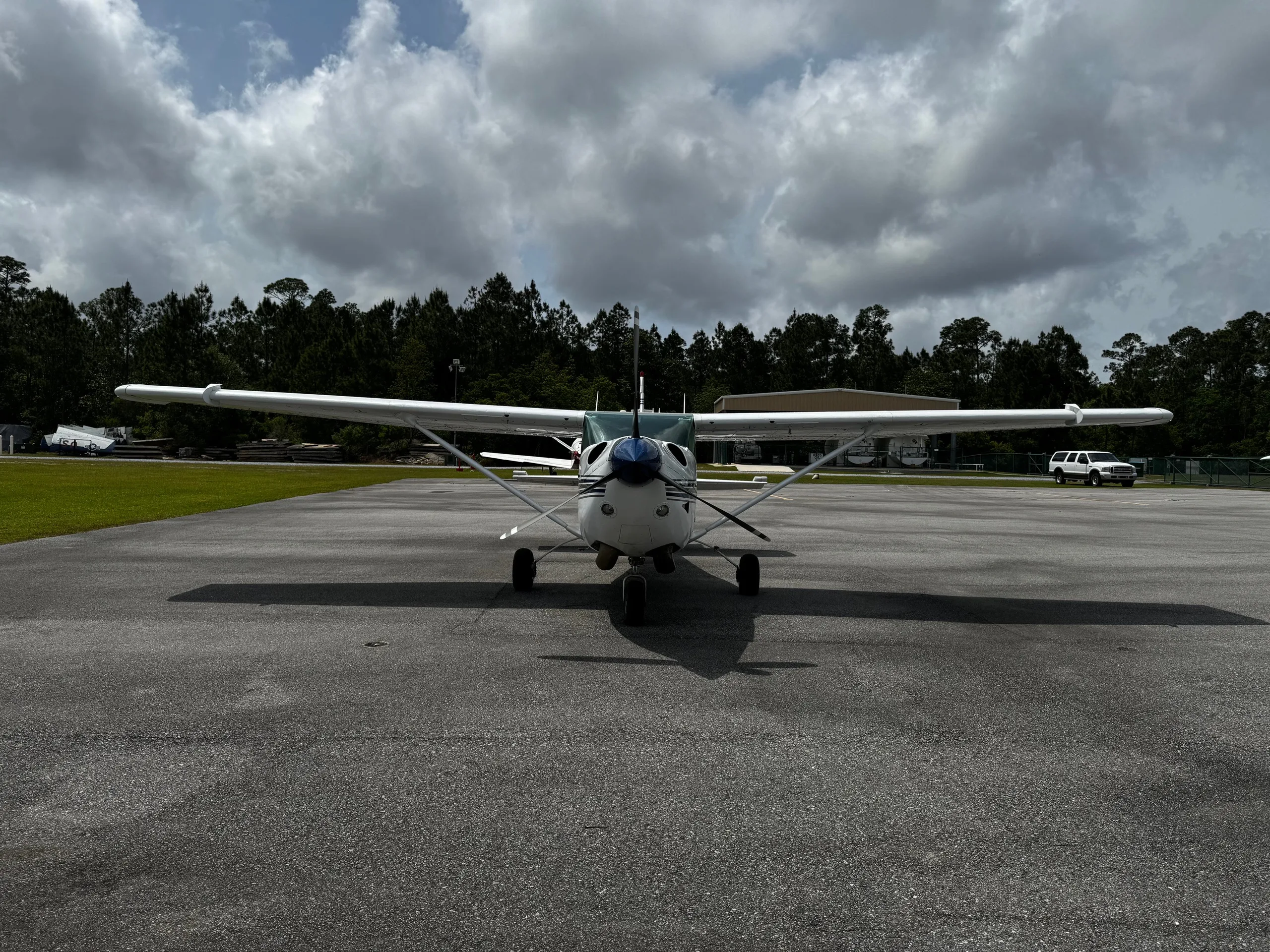 Front view of a white and blue Cessna 206 Turbo Stationair on the tarmac.