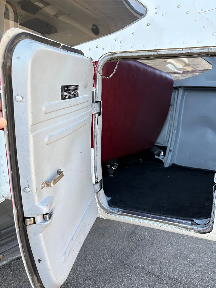 The open cargo door and cargo area of the aircraft with a red back panel.