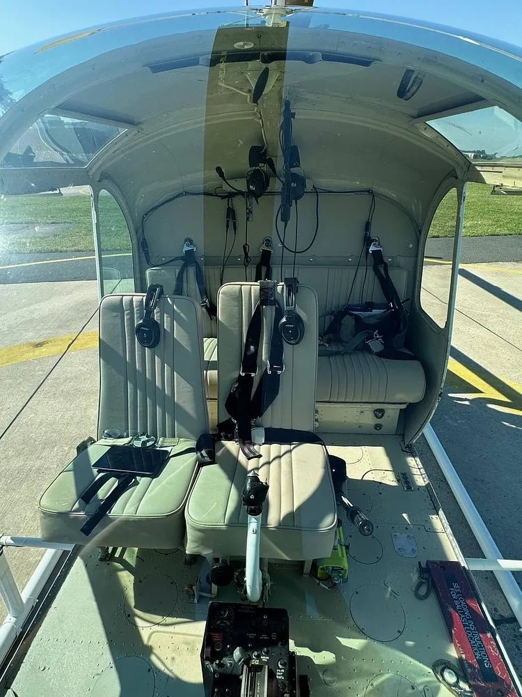 The interior of the Hiller UH-12 helicopter showing two front seats and a rear bench seat.