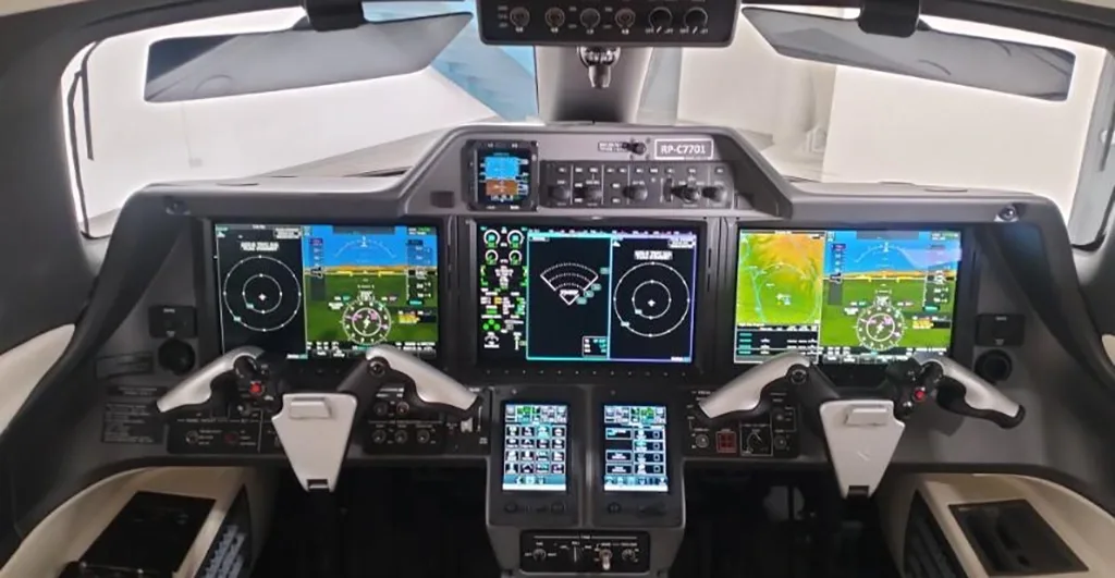 The modern cockpit of a private jet with multiple digital displays and flight controls.