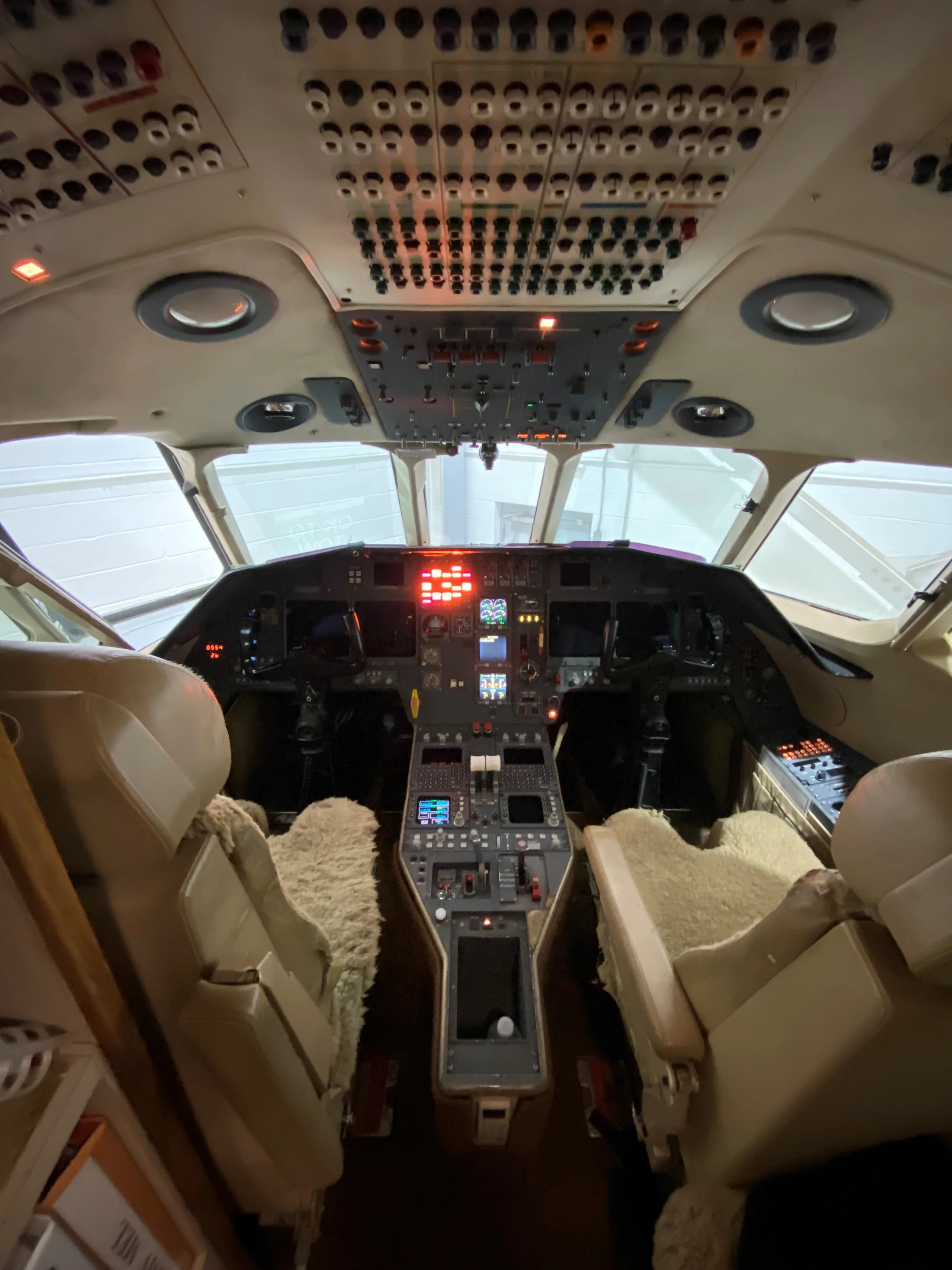 View of the aircraft's cockpit featuring the instrument panel and seats.