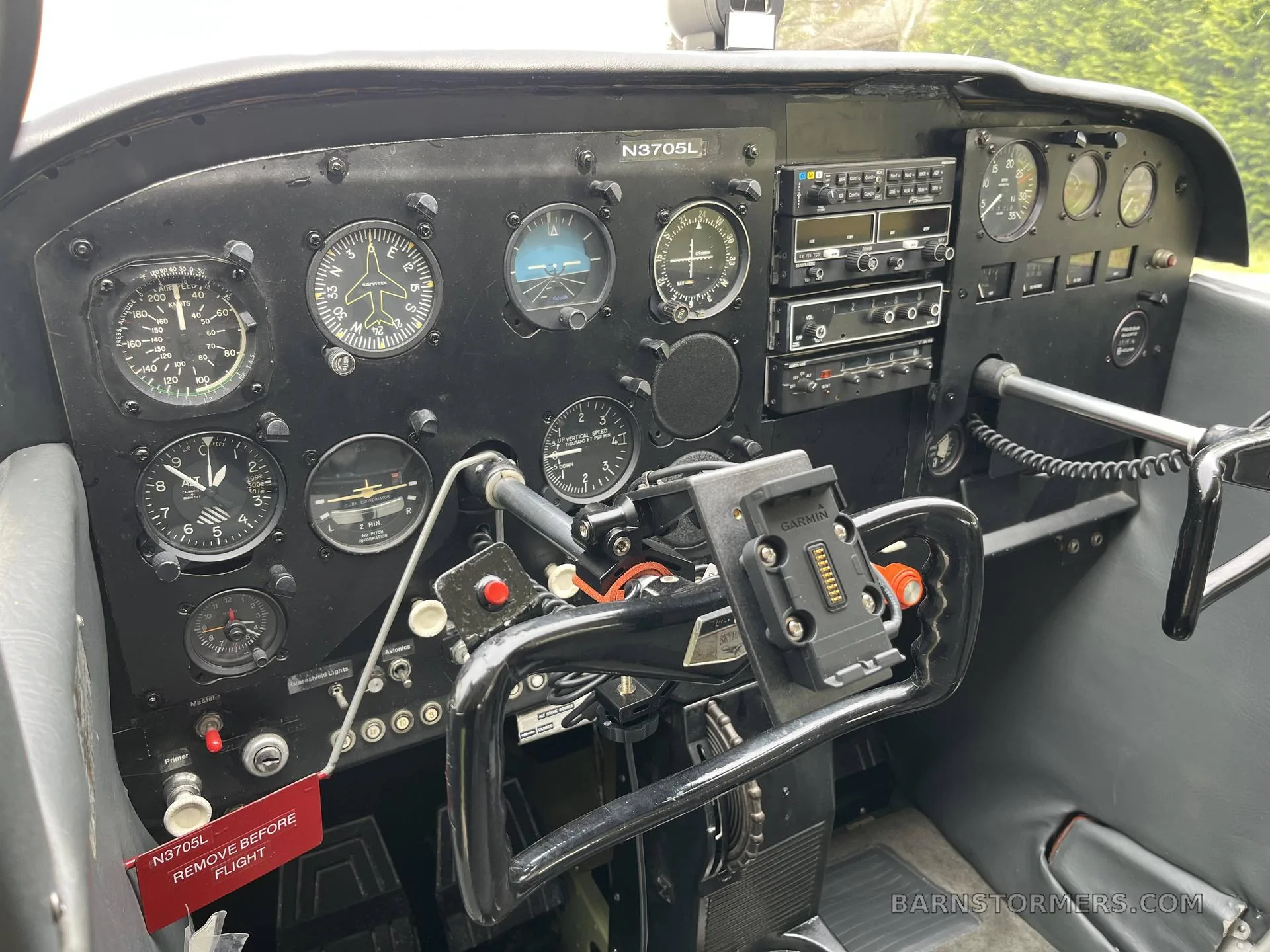 The black instrument panel of a Cessna Skyhawk (N3705L) features analog gauges, radio stack, and a control yoke with a Garmin mount.
