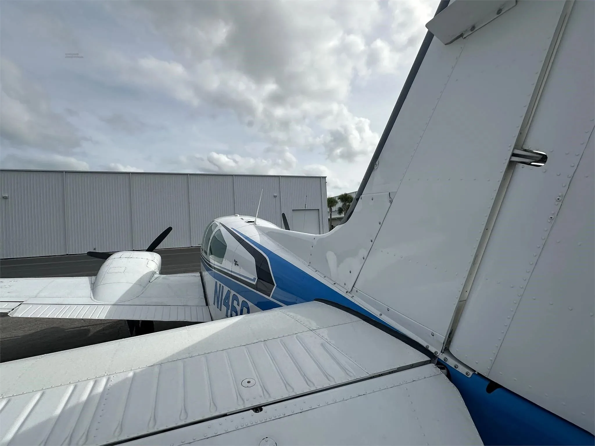 A close-up view of the tail and right wing of the white and blue aircraft N146C.