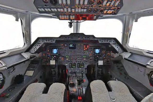 The cockpit of a business jet with multiple screens and controls, viewed from the pilot's seat.