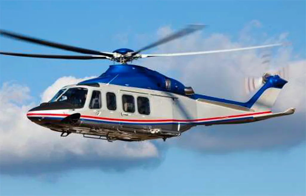 A blue and white helicopter with a red stripe flying against a blue sky with clouds.