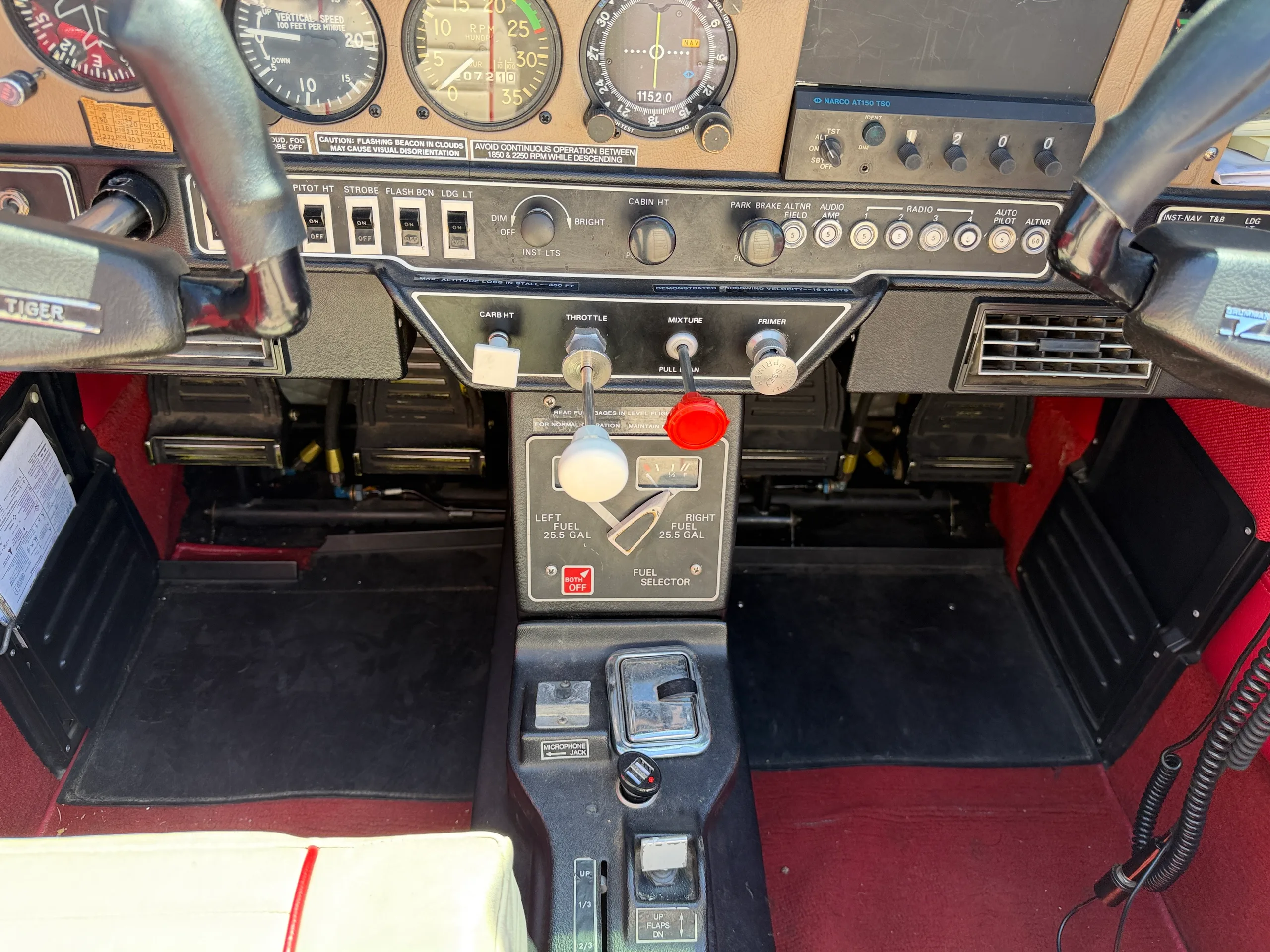 A close-up of the central console in the cockpit, showing the throttle, mixture, and fuel selector controls.