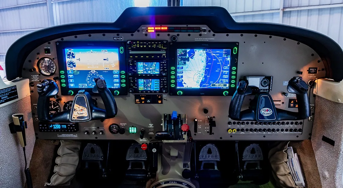 The cockpit instrument panel of an aircraft, featuring multiple digital displays and controls.